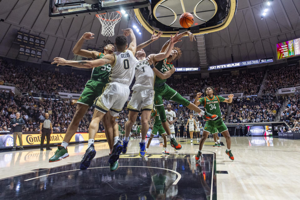 Florida A&M forward Saiyd Burnside (22) knocks the ball away from Purdue forward Caleb Furst (1) during the second half of an NCAA college basketball game Thursday, Dec. 29, 2022, in West Lafayette, Ind. (AP Photo/Doug McSchooler)