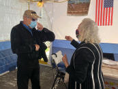 In this photo provided by Larry Brandspiegel, Holocaust survivors Israel "Sasha" Eisenberg, left, and Ruth Brandspiegel are reunited on Oct. 3, 2020, in East Brunswick, N.J. for the first time in more than 70 years since their families left the Hallein Displaced Persons Camp in Austria. They met under a sukkah, a temporary shelter used to celebrate the weeklong Jewish fall holiday of Sukkot. (Larry Brandspiegel via AP)