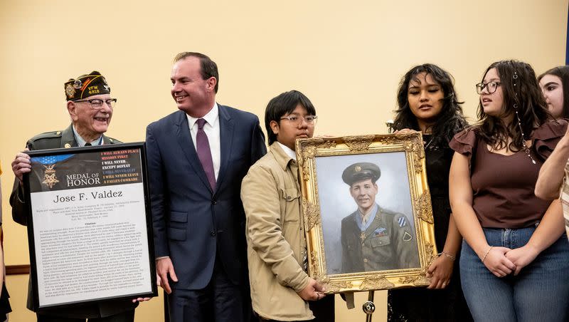World War II and Korean War veteran Robert T. Bates and Sen. Mike Lee, R-Utah, stand with Orem High Latinos in Action holding a painting of Jose F. Valdez, Utah’s only Hispanic Medal of Honor recipient, at the state Capitol in Salt Lake City Friday. 