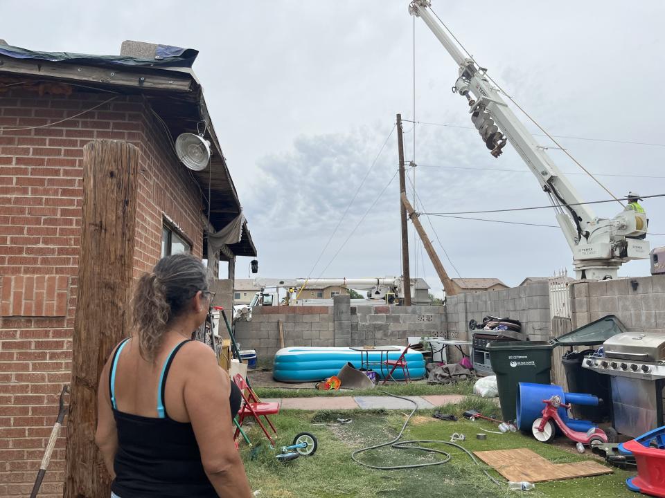 Frances Byers looks on as SRP crews repair a fallen power line