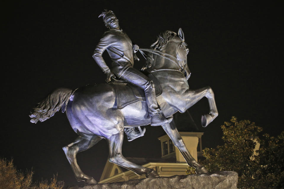 The statue titled Rumor's of War by artist Kehinde Wiley gets fully unveiled after the tarp covering the statue got stuck for a while at the Virginia Museum of Fine Arts in Richmond, Va., Tuesday, Dec. 10, 2019. The monumental bronze sculpture of a young black man astride a galloping horse was unveiled Tuesday, set to be permanently installed in Virginia's capital city, not far from the Confederate monument it mimics. (AP Photo/Steve Helber)