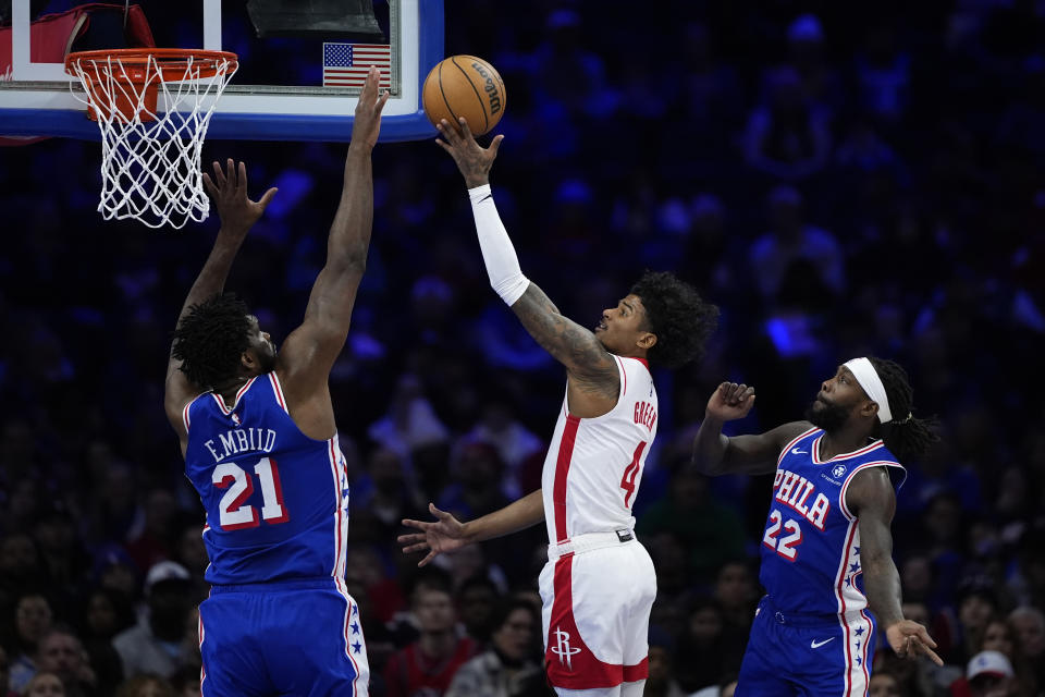 Houston Rockets' Jalen Green, center, goes up for a shot against Philadelphia 76ers' Joel Embiid, left, and Patrick Beverley during the first half of an NBA basketball game, Monday, Jan. 15, 2024, in Philadelphia. (AP Photo/Matt Slocum)