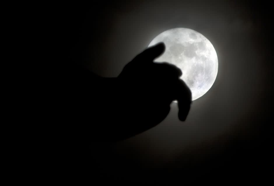 Rising over the hand of Saad Zaghloul statue, an Egyptian revolutionary and statesman, in Cairo, Egypt, Monday, Nov. 14, 2016. The brightest moon in almost 69 years, a phenomenon known as the supermoon, is lighting up the sky in a treat for star watchers around the globe.