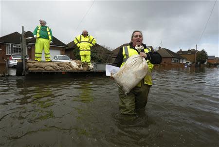 Community volunteers deliver sandbags to residents at Egham after the River Thames burst its banks and caused flooding in southeast England February 13, 2014. REUTERS/Luke MacGregor