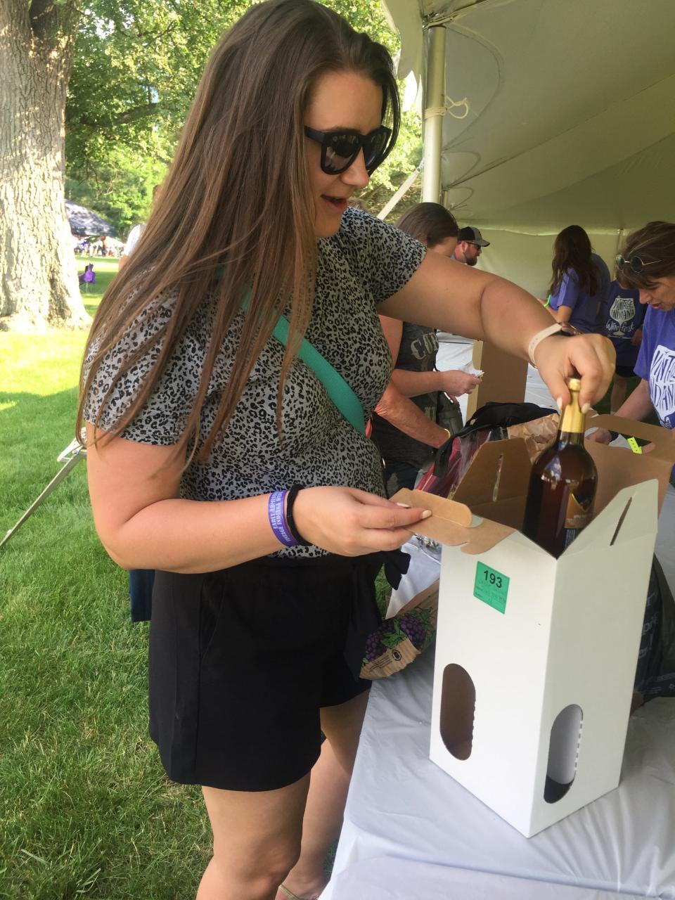 Leah Jeffries, of Carmel, packs up her purchases from the 2021 Vintage Indiana Wine Fest at Military Park.