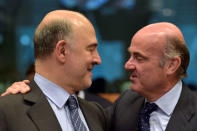 European Economic and Financial Affairs Commissioner Pierre Moscovici (L) chats with Spain's Economy Minister Luis de Guindos during a Euro zone finance ministers meeting to discuss whether Greece has passed sufficient reforms to unblock new loans and how international lenders might grant Athens debt relief, in Brussels, Belgium May 24, 2016. REUTERS/Eric Vidal