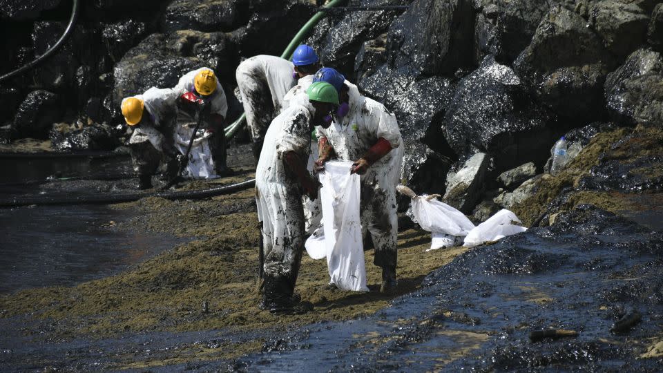 Workers clean up an oil spill on Rockly Bay beach in Scarborough, Trinidad and Tobago, on February 10, 2024. The origin of the ship that caused the spill is not yet known. - Akash Boodan/AP