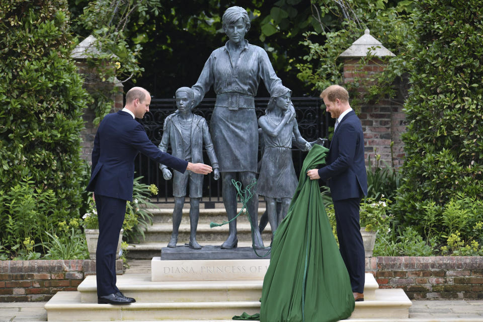 El príncipe Guillermo de Inglaterra, a la izquierda, y su hermano, el príncipe Enrique, develan una estatua que encargaron de su madre, la princesa Diana, en el que habría sido su 60 cumpleaños, el jueves 1 de julio de 2021 en el Jardín Hundido del Palacio de Kensington, en Londres. (Dominic Lipinski /Pool Photo via AP)