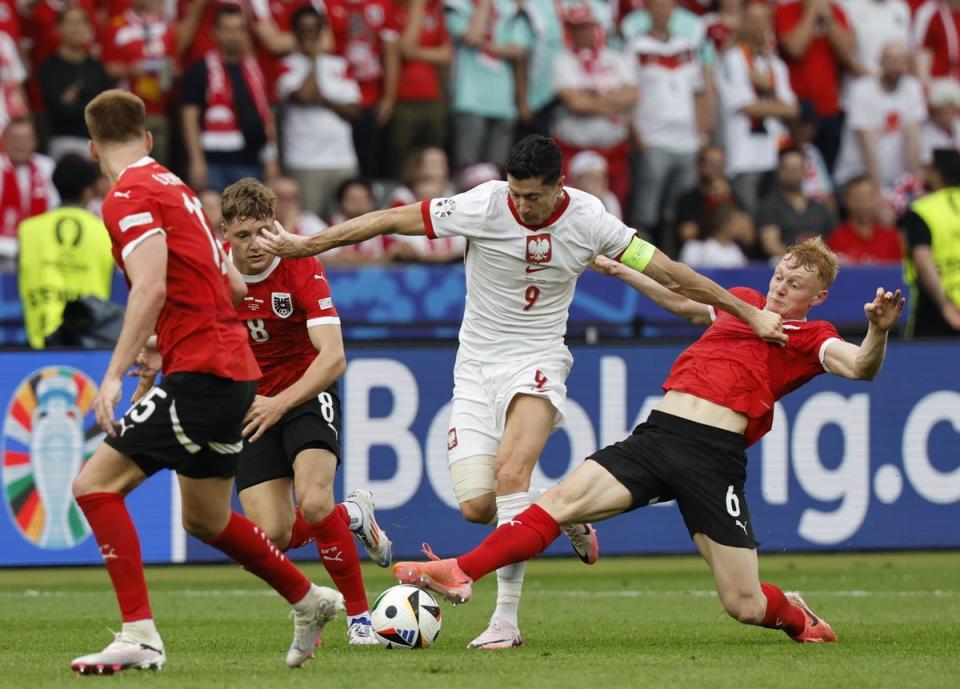 Robert Lewandowski (C) of Poland and Nicolas Seiwald (R) of Austria in action (EPA)