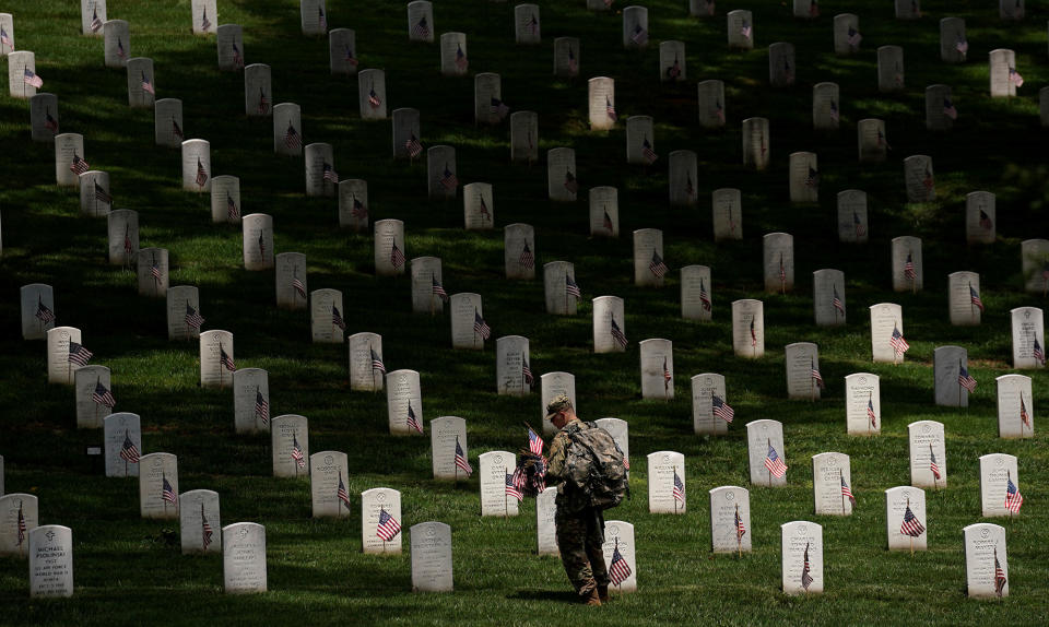 <p>A soldier from the 3rd U.S. Infantry Regiment (Old Guard) takes part in Flags-in, where a flag is placed at each of the 284,000 headstones at Arlington National Cemetery ahead of Memorial Day, in Arlington, Va., May 25, 2017. (Kevin Lamarque/Reuters) </p>