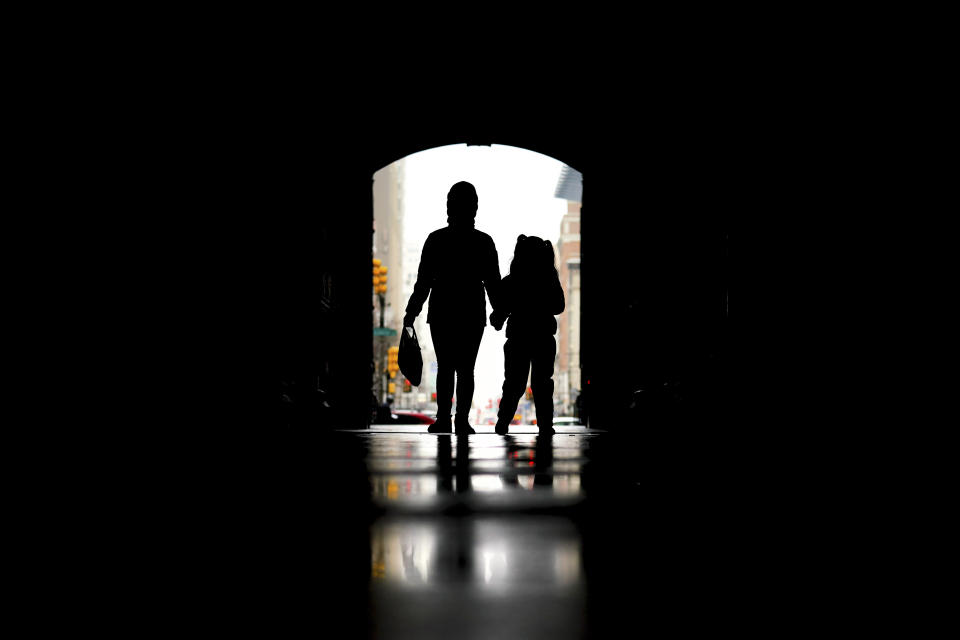 FILE - Pedestrians pass beneath City Hall in Philadelphia, Feb. 3, 2022. A major effort to overhaul care for Americans with mental health and drug problems is gaining traction in Washington as Congress and the Biden administration work on overlapping plans. Top goals include responding to the mental health crisis among youth, increasing the supply of trained counselors and clinicians, narrowing the gap between care for physical and mental health problems, and preserving access to telehealth services. (AP Photo/Matt Rourke, File)