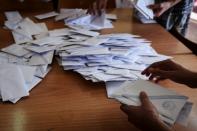 Officials count the ballots at a polling station in Athens