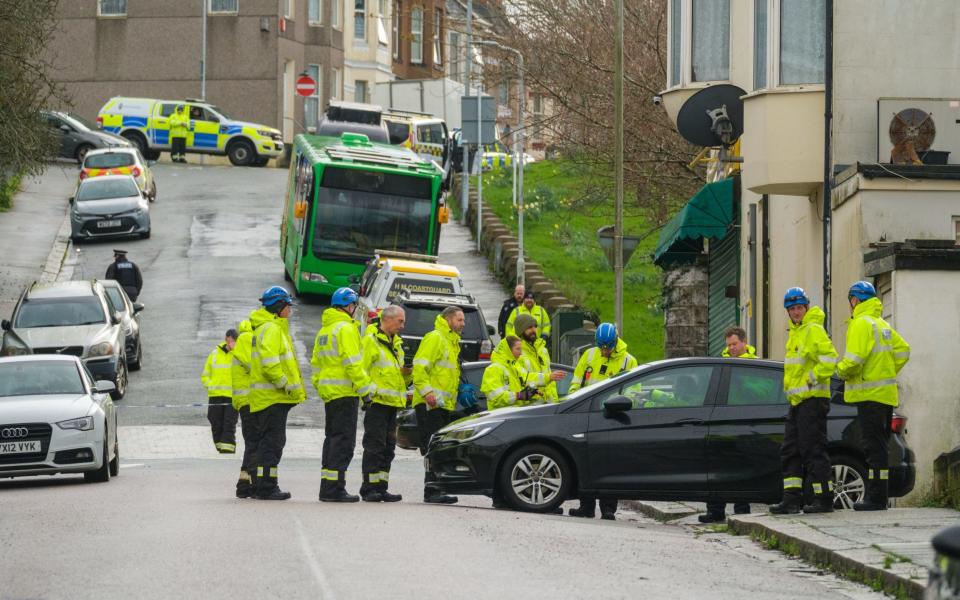 Members of HM Coastguard Search and Rescue, gather at a cordon