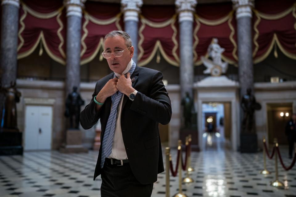 Rep. Brian Fitzpatrick, R-Pa., ties a tie as he walks through National Statuary Hall at the U.S. Capitol on January 12, 2024 in Washington, DC.