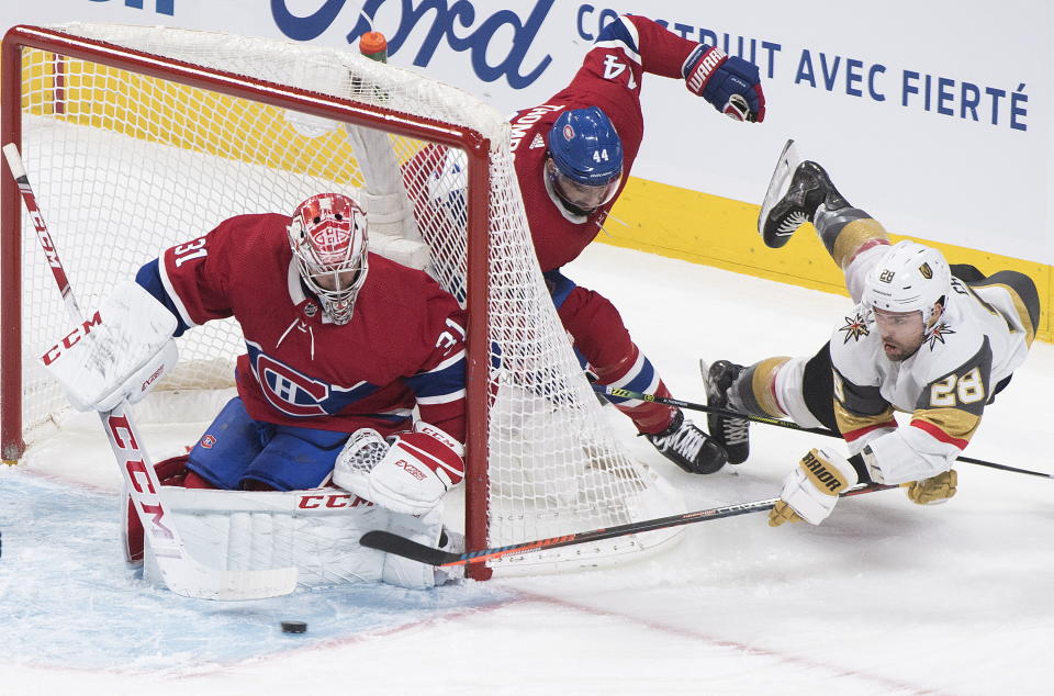 Vegas Golden Knights' William Carrier (28) lunges for the puck as he moves in against Montreal Canadiens goaltender Carey Price as Canadiens' Nate Thompson (44) defends during first-period NHL hockey game action in Montreal, Saturday, Jan. 18, 2020. (Graham Hughes/The Canadian Press via AP)