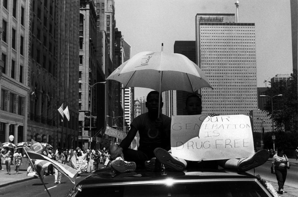 <p>Two boys riding on the roof of a car in the Fourth of July Parade, hold a sign that reads: “Our generation is drug free,” on Michigan Avenue near Adams Street, Chicago, Ill., 1988. (Photo: David Dapogny/Chicago History Museum/Getty Images) </p>