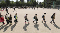 Students wearing face masks as a precaution against the new coronavirus, walk to their classrooms while maintaining social distancing after they attend the entrance ceremony at Chungwoon elementary school in Seoul, South Korea, Wednesday, May 27, 2020. More than 2 million high school juniors, middle school seniors, first- and second-grade elementary school children and kindergartners were expected to return to school on Wednesday. (Lee Jin-wook/Yonhap via AP)