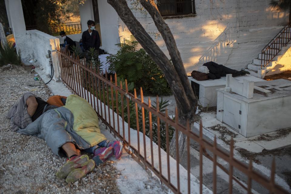 Migrants sleep at a cemetery near the Moria refugee camp on the northeastern island of Lesbos, Greece, Thursday, Sept. 10, 2020. A second fire in Greece's notoriously overcrowded Moria refugee camp destroyed nearly everything that had been spared in the original blaze, Greece's migration ministry said Thursday, leaving thousands more people in need of emergency housing. (AP Photo/Petros Giannakouris)