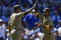 San Diego Padres designated hitter Luis Arraez, right, high-fives Manny Machado after scoring on a double from Jake Cronenworth during the fifth inning of a baseball game Wednesday, May 8, 2024, in Chicago. (AP Photo/Erin Hooley)