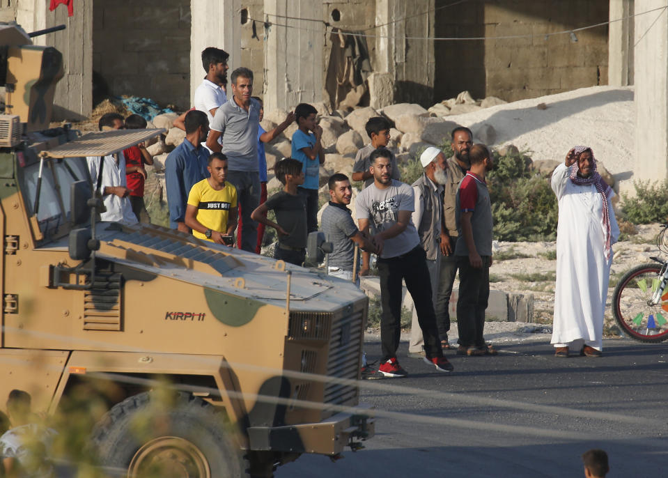 FILE-In this Wednesday, Oct. 9, 2019 file photo, shortly after the Turkish operation inside Syria had started, a convoy of Turkish forces vehicles is driven through the town of Akcakale, Sanliurfa province, southeastern Turkey, at the border between Turkey and Syria. Since Turkey announced its incursion into neighbouring Syria to clear out Kurdish fighters last week, patriotic sentiment has run high with many public signs of support for the military. (AP Photo/Lefteris Pitarakis, File)