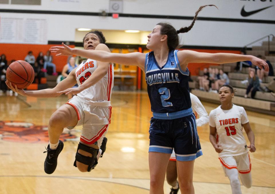 Massillon's Kaliyah Hewitt goes to the hoop with defense from Louisville's Courtney Barwick in the first half at Massillon Thursday, January 5, 2023. 