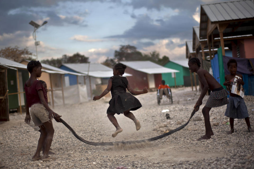 In this picture taken on Feb. 15, 2012, a child jumps rope at La Piste camp in Port-au-Prince, Haiti. While the 1.3 million people displaced by the quake ended up in post-apocalyptic-like tent cities, a sliver of the homeless disabled population landed in the near-model community of La Piste, with plywood shelters along tidy gravel lanes in a settlement designed to house them. The rare respite for the estimated 500-plus people living at the camp is coming to an end as the government moves to reclaim the land. (AP Photo/Ramon Espinosa)