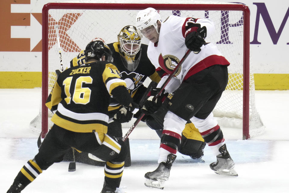Ottawa Senators' Julien Gauthier (77) cannot get his stick on the puck in front of Pittsburgh Penguins goaltender Tristan Jarry (35) during the second period of an NHL hockey game in Pittsburgh, Monday, March 20, 2023. (AP Photo/Gene J. Puskar)