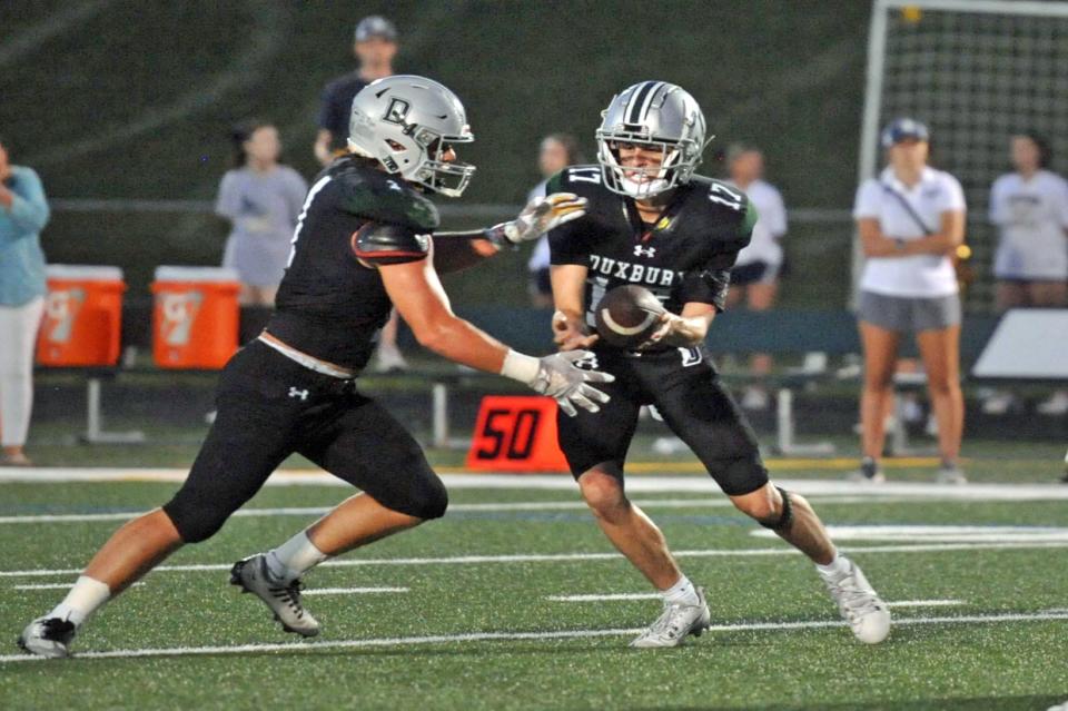 Duxbury's Alex Barlow, left, takes the hand-off from quarterback Finn Carley, right, during high school football at Duxbury High School, Thursday, Sept. 7, 2023. Tom Gorman/For The Patriot Ledger