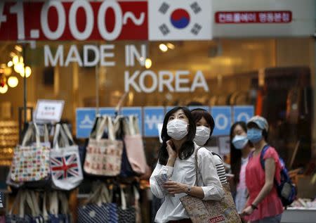 Tourists wearing masks to prevent contracting Middle East Respiratory Syndrome (MERS) look around Myeongdong shopping district in central Seoul, South Korea, June 11, 2015. REUTERS/Kim Hong-Ji