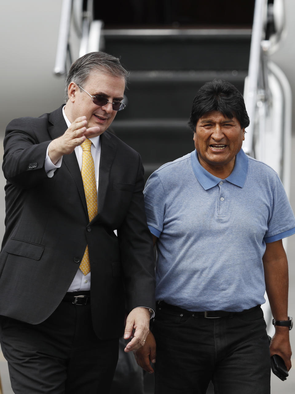 Mexican Foreign Minister Marcelo Ebrard, left, welcomes former Bolivian President Evo Morales upon his arrival in Mexico City, Tuesday, Nov. 12, 2019. Mexico granted asylum to Morales, who resigned on Nov. 10 under mounting pressure from the military and the public after his re-election victory triggered weeks of fraud allegations and deadly protests. (AP Photo/Eduardo Verdugo)