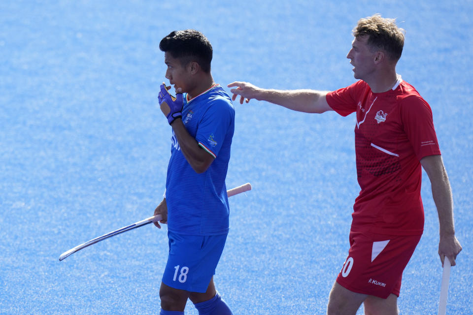 India's Nilakanta Sharma, wait with England's Christopher Griffiths for play to restart during pool B hockey match between India and England at the Commonwealth Games in Birmingham, England, Sunday, July 31, 2022. (AP Photo/Alastair Grant)