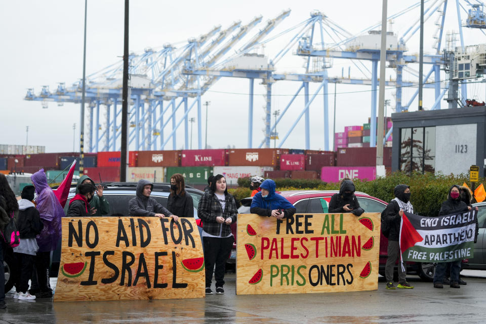 FILE - Protesters against the Israel-Hamas war hold up large wooden signs as they block the main Port of Tacoma entrance to delay the loading of the Cape Orlando vessel, Monday, Nov. 6, 2023, in Tacoma, Wash. Watermelons have appeared on banners, t-shirts, balloons and social media posts over the past three months in global protests against the Israel-Hamas war. The fruit has increasingly come to be recognized as a symbol of Palestinian resistance and a global sign of solidarity. (AP Photo/Lindsey Wasson, File)