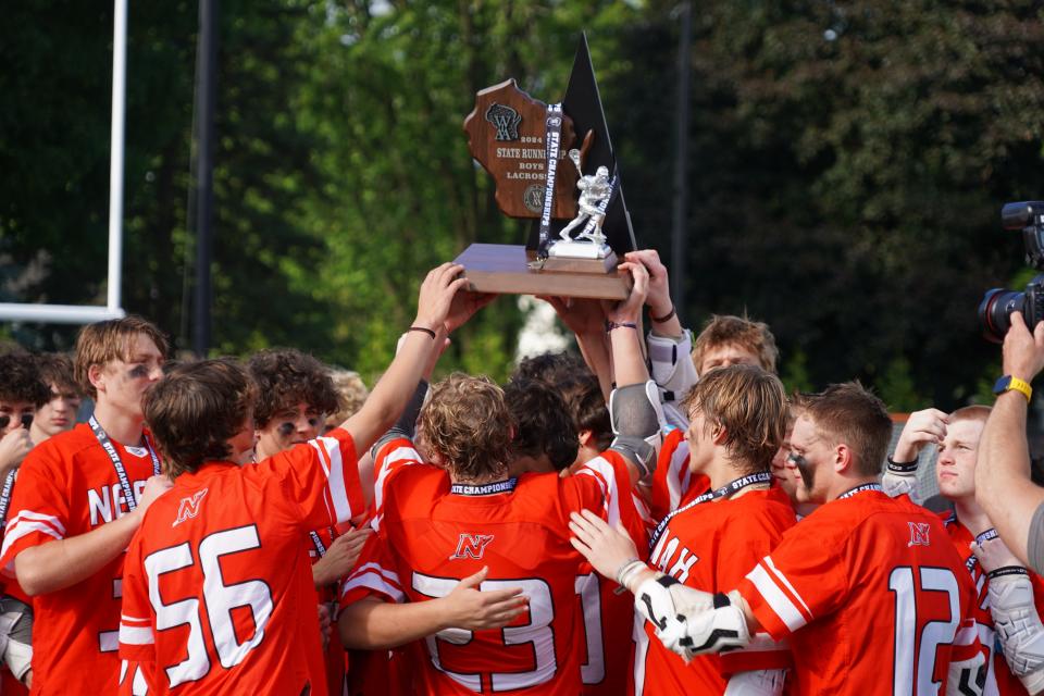 Neenah players hoist the WIAA state boys lacrosse runner-up trophy after falling 7-6 to Middleton in the inaugural state championship game Saturday in Sun Prairie.