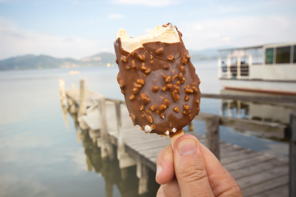 chocolate ice cream / Hand holding bitten ice cream / Ice Cream holded by hand /  hand holding ice cream / ice cream