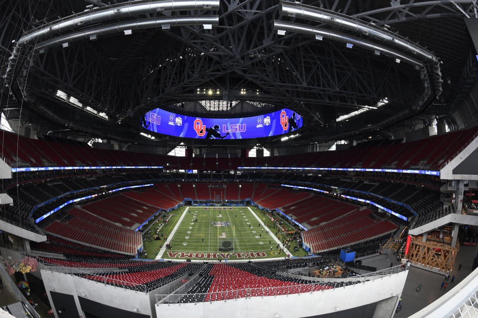 FILE - In this Dec. 28, 2019, file photo, The Mercedes-Benz stadium is shown prior to the Peach Bowl NCAA college football playoff game between LSU and Oklahoma in Atlanta. The Final Four teams would've been in Atlanta, getting in their final practices for Saturday's semifinal games. The $1.5 billion stadium, a retractable-roof wonder normally used for football and soccer, would have undergone a hasty reconfiguration to essentially construct a new lower deck stretching all the way to courtside. Those seats would've been filled with 80,000 fans. (AP Photo/Danny Karnik, File)