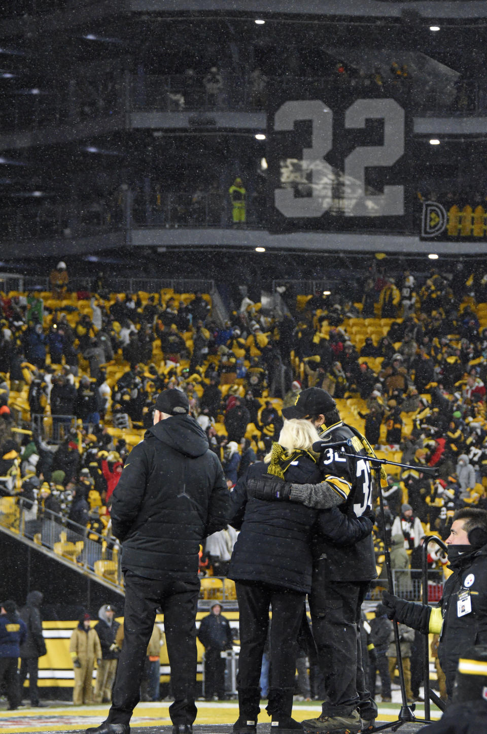 Pittsburgh Steelers owner Art Rooney II, left, and Franco Harris' widow Dana, center, and son Dok, attend a ceremony to retire Harris' No. 32 jersey at half-time of an NFL football game against the Las Vegas Raiders, Saturday, Dec. 24, 2022. Harris, a four-time Super Bowl champion, passed away Dec. 21, 2022, at the age of 72. (AP Photo/Don Wright)