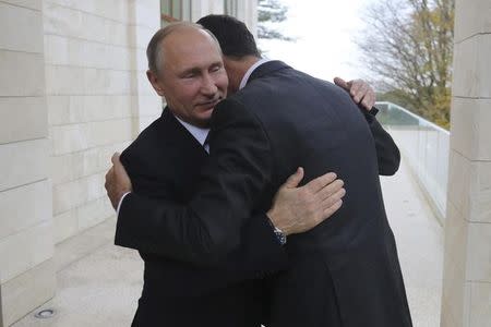 Russian President Vladimir Putin (L) welcomes Syrian President Bashar al-Assad during a meeting in the Black Sea resort of Sochi, Russia November 20, 2017. Sputnik/Mikhail Klimentyev/Kremlin via REUTERS