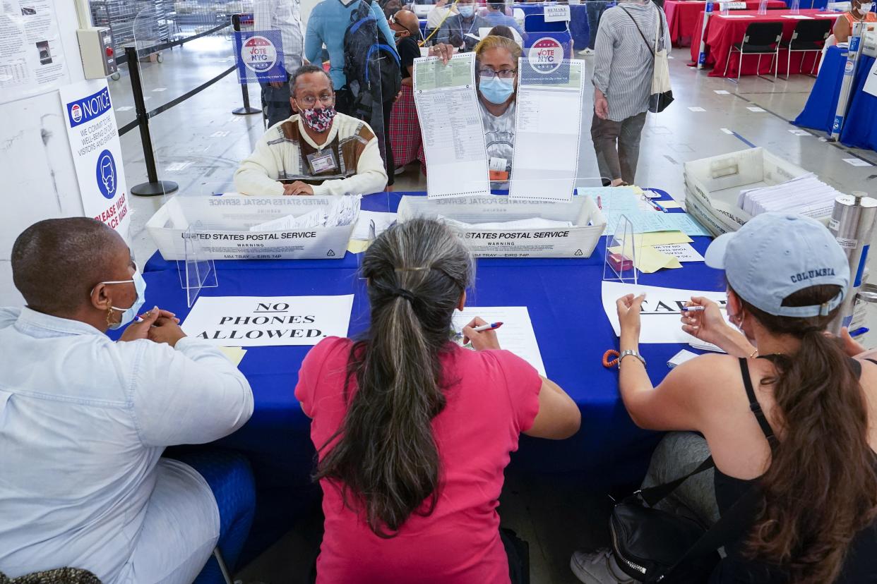 New York City Board of Elections staff members, background, show a ballot to campaign observers as they count absentee ballots in the primary election, Friday, July 2, 2021, in New York.