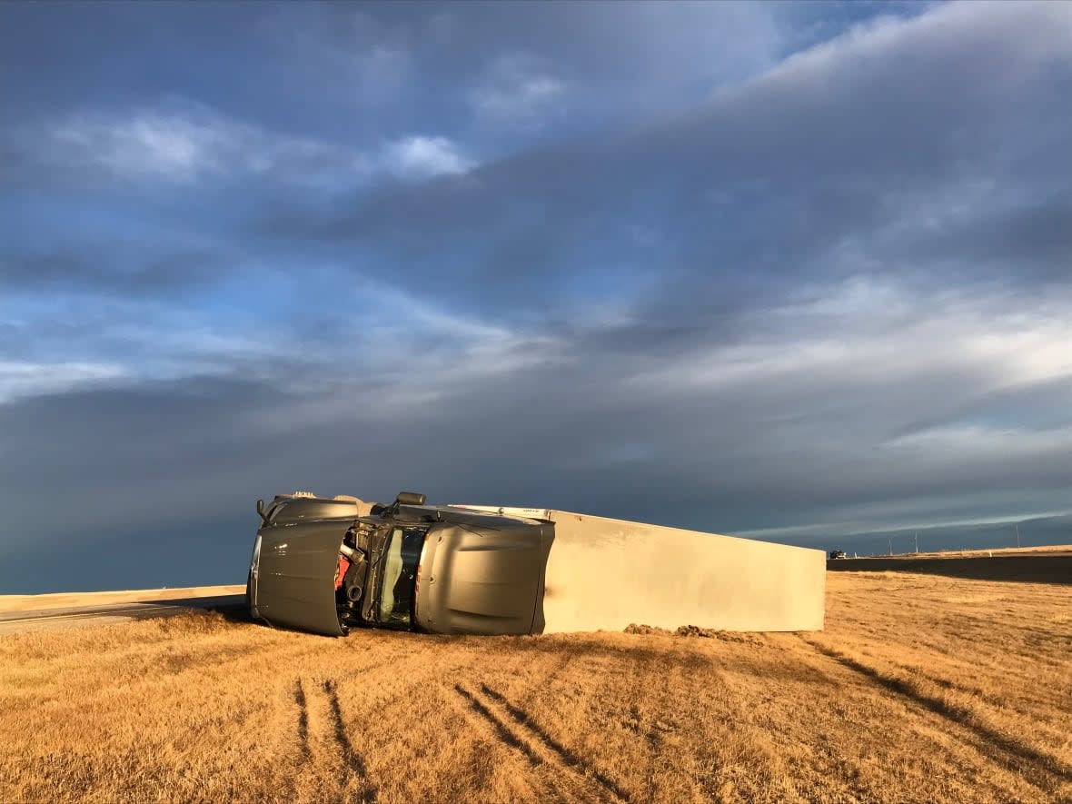 Westerly wind gusts approaching 100 km/h along the Foothills have led to multiple rollovers on southern Alberta roadways, including this one on Highway 2 south of Nanton, and are pushing a wildfire still out of control east. (Dave Gilson/CBC - image credit)