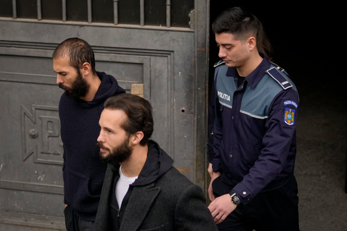 File: Police officers escort Andrew Tate handcuffed to his brother Tristan, right, from the Court of Appeal (AP)