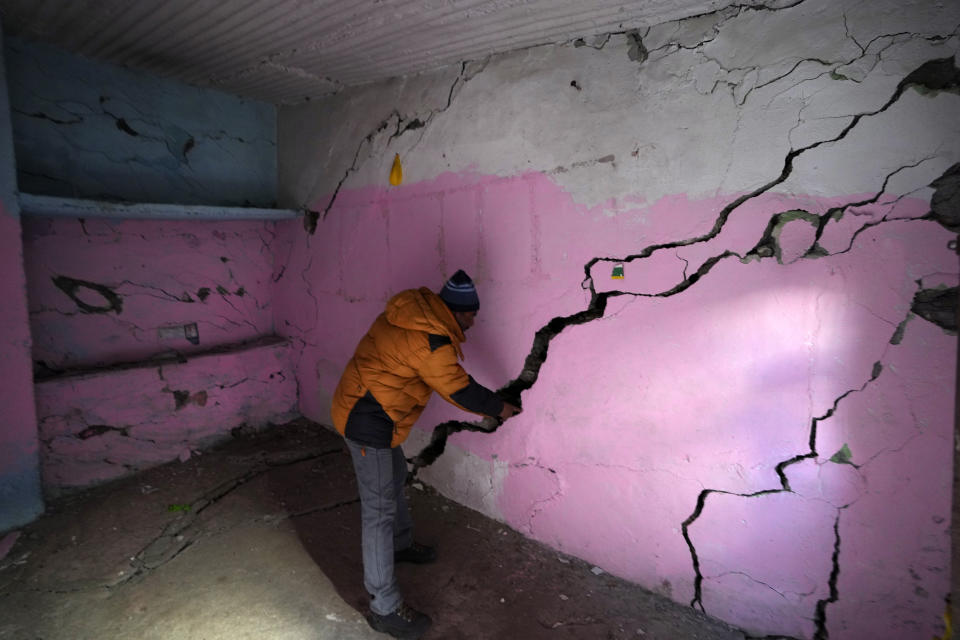 Rajendra Lal, shows multiple cracks in the walls of his house, in Joshimath, in India's Himalayan mountain state of Uttarakhand, Jan. 19, 2023. Big, deep cracks had emerged in over 860 homes in Joshimath, where they snaked through floors, ceilings and walls, making them unlivable. Roads were split with crevices and multi-storied hotels slumped to one side. Authorities declared it a disaster zone and came in on bulldozers, razing down whole parts of a town that had become lopsided. (AP Photo/Rajesh Kumar Singh)