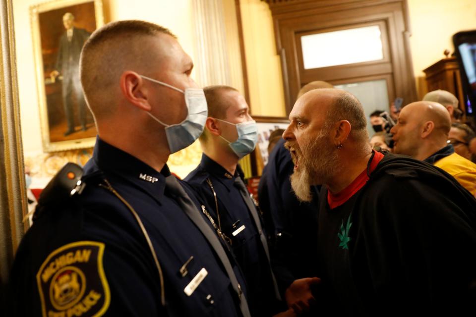 Protestors try to enter the Michigan House of Representative chamber and are being kept out by the Michigan State Police after the American Patriot Rally organized by Michigan United for Liberty protest for the reopening of businesses on the steps of the Michigan State Capitol in Lansing, Michigan on April 30, 2020. - The group is upset with Michigan Gov. Gretchen Whitmer's mandatory closure to curtail Covid-19. (Photo by JEFF KOWALSKY / AFP) (Photo by JEFF KOWALSKY/AFP via Getty Images)