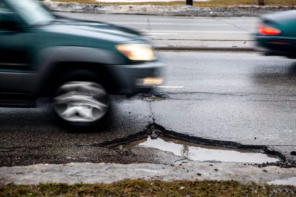 Drivers dodge pot holes along Fleur Drive on Wednesday, March 13, 2019, in Des Moines.