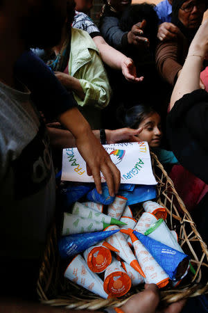 Charity workers distribute ice cream to the guests of the Community of Sant'Egidio Centre in Rome, Italy, April 23, 2018. REUTERS/Alessandro Bianchi