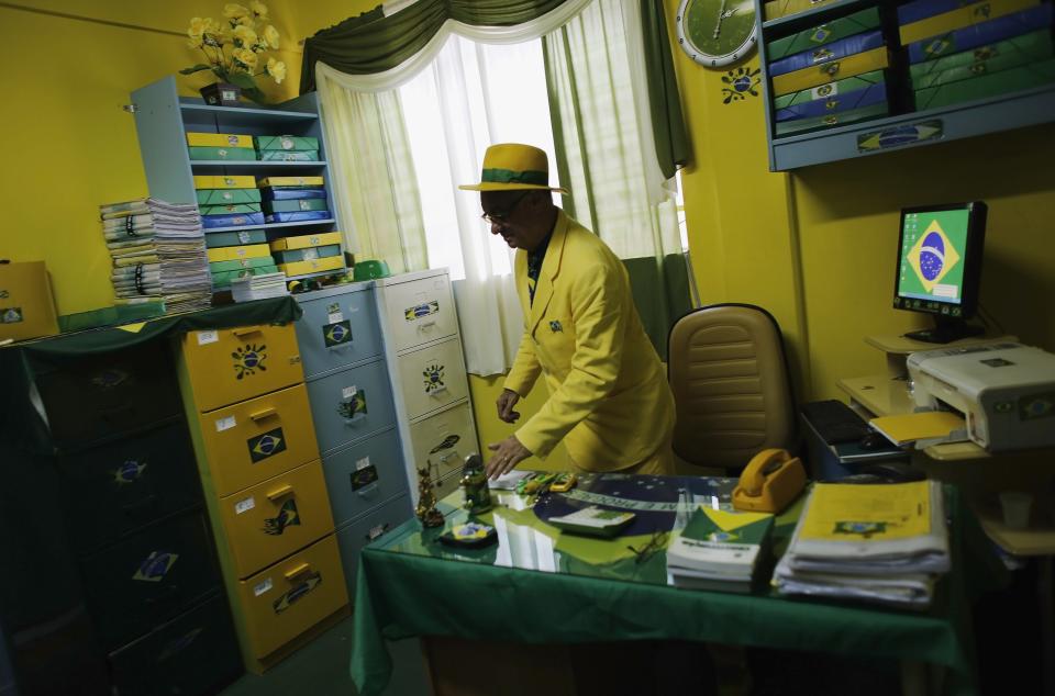 Brazilian attorney, Nelson Paviotti, gets up from his desk in his office decorated with the colors of the national flag in Campinas