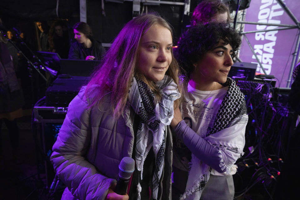 Climate activist Greta Thunberg, left, is hugged by Afghan Sahar Shirzad after Thunberg was interrupted by a climate activist for expressing solidarity with the Palestinians as tens of thousands of people marched through Amsterdam, Netherlands, Sunday, Nov. 12, 2023, to call for more action to tackle climate change. Thunberg was among the speakers at the march that comes 10 days before national elections in the Netherlands. (AP Photo/Peter Dejong)