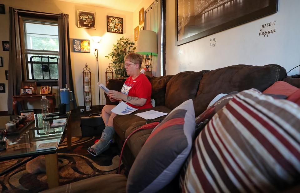 Candy Lauderdale sifts through paperwork related to her eviction.