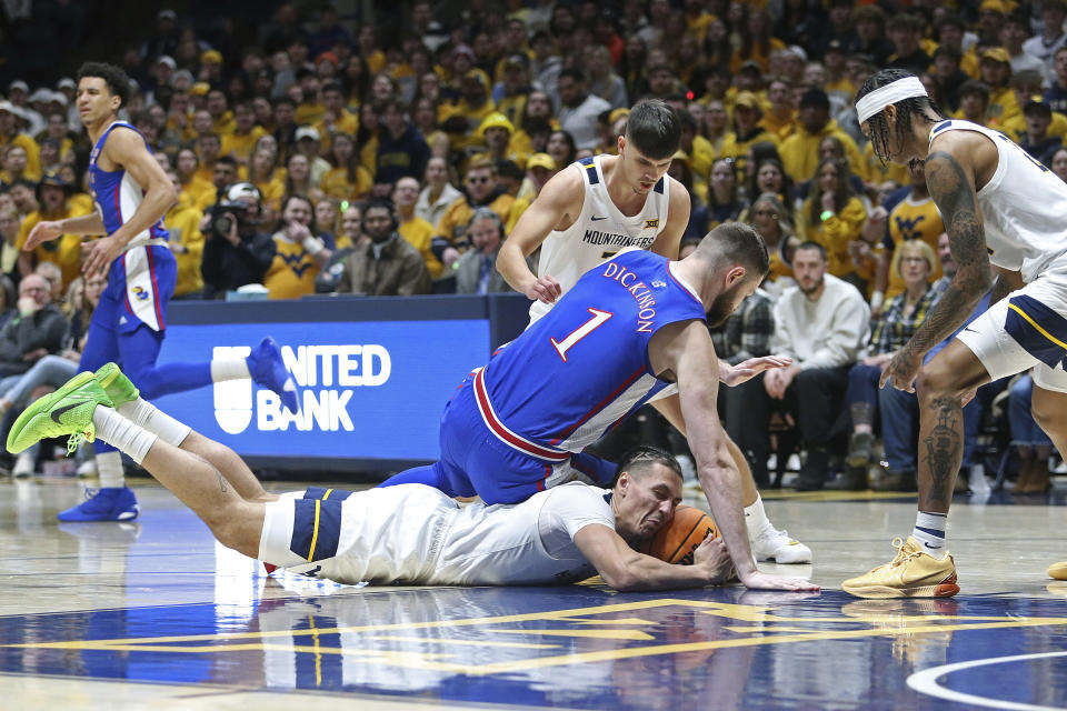 West Virginia forward Patrick Suemnick (24) is defended by Kansas center Hunter Dickinson (1) during the first half of an NCAA college basketball game on Saturday, Jan. 20, 2024, in Morgantown, W.Va. (AP Photo/Kathleen Batten)