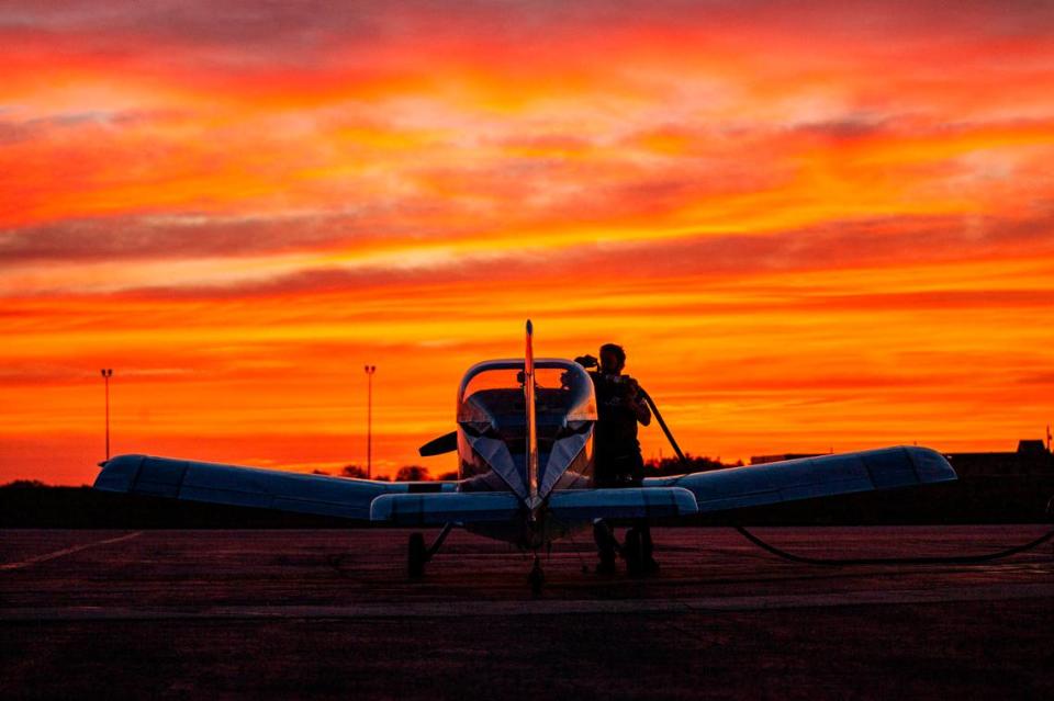 Mujahid Abdulrahim, a Kansas City area pilot and assistant professor at the University of Missouri—Kansas City, stands outside his plane during a morning sunrise.