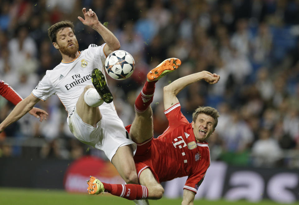 Real's Xabi Alonso, left, and Bayern's Thomas Mueller challenge for the ball during a Champions League semifinal first leg soccer match between Real Madrid and Bayern Munich at the Santiago Bernabeu stadium in Madrid, Spain, Wednesday, April 23, 2014 .(AP Photo/Paul White)